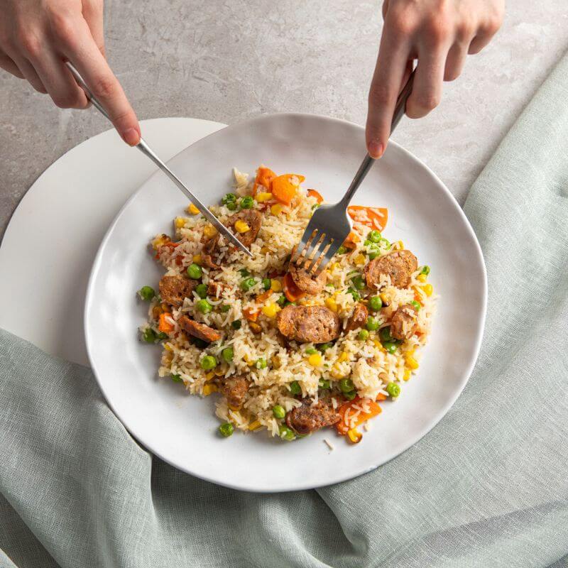 Our take on the classic Fried Rice served on a white ceramic plate on a marble bench top with a teal coloured cloth underneath.